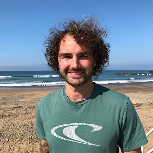 A smiling team member on the beach